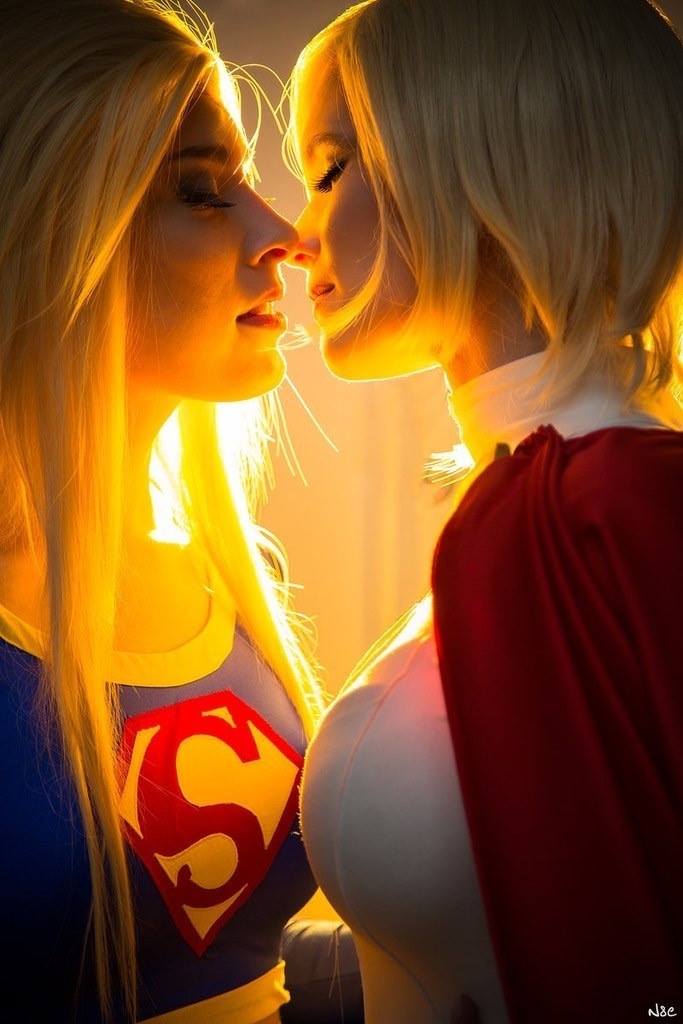 Supergirl And Wonderwoman Looking Into Each Othe